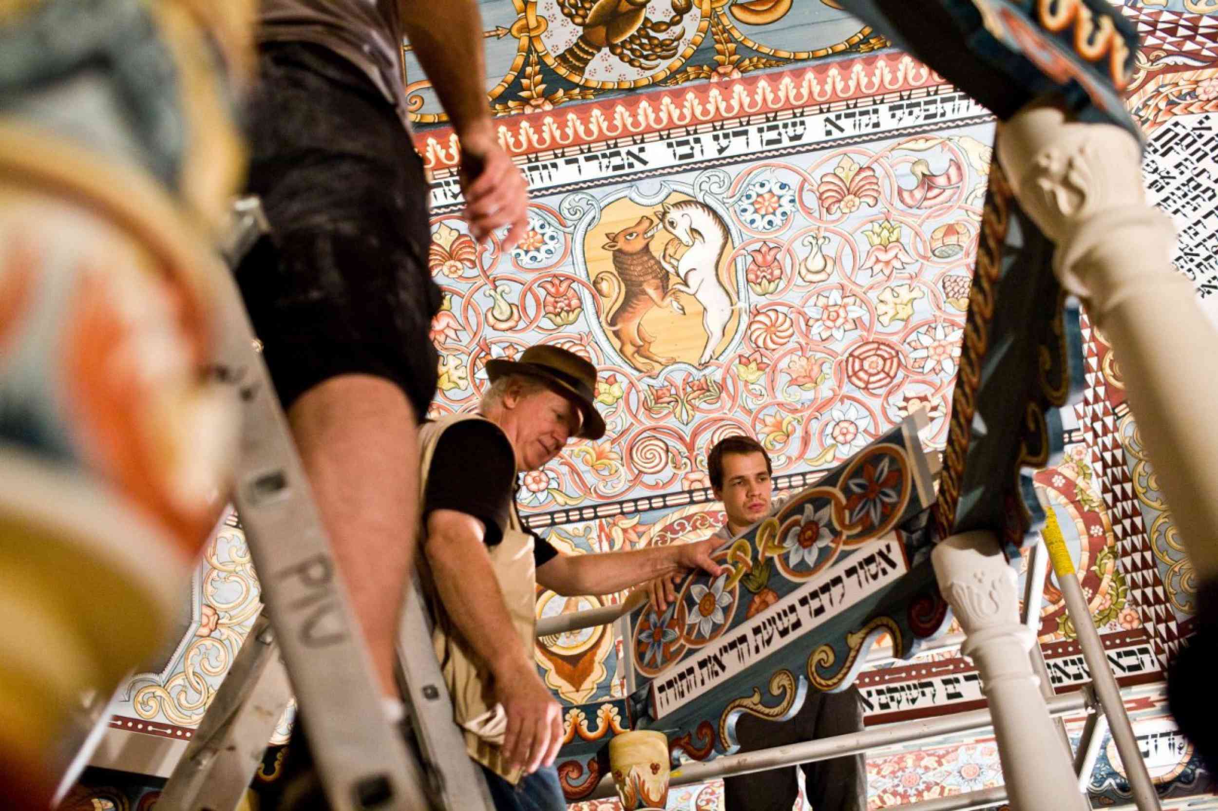 Rick Brown (center) positions a piece of the bimah in the newly reconstructed Gwoździec Synagogue. Photo: Magda Starowieyska, Museum of the History of Polish Jews.